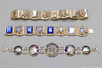 Three bracelets laid flat showing panel and disc styles