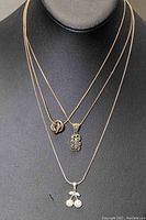 Front view of three 925 silver necklaces with distinctive pendants displayed on a black jewelry bust.