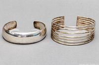 Two silver cuff bangles side by side showing full top view