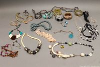 Full view of all assorted costume jewelry including bangles, bracelets, and necklaces spread on a flat surface.