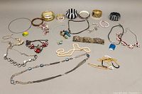 Photo showing full assortment of costume bangles and necklaces arranged on a neutral background.