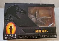 Front view of the Jurassic Park Hammond Collection Triceratops figure in original black box with visible window and logo.