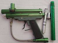 Green Spyder Victor Aggressor XT paintball marker with black grip and silver accessories shown from side angle
