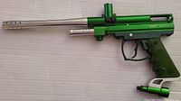 Side view of green Spyder Victor II paintball marker with silver barrel and black trigger.