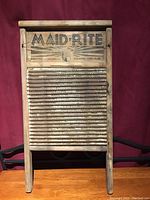 Front view of Maid-Rite washboard with wooden frame and ribbed metal wash surface, 'Maid-Rite' label on top indicating origin Columbus Ohio USA.