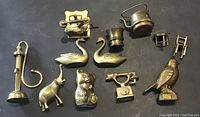 Top-down view of all 11 brass figurines arranged on a dark surface