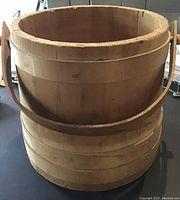 Front and side view of natural wood bucket, showing wood slat construction and handle.
