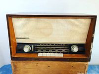 Front view showing wood cabinet, speaker grille cloth, tuning dial and control knobs