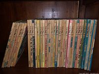 Photo showing a wide view of approx. 20 Dr. Seuss books lined up vertically on a shelf with colorful spines, showing titles like The Cat in the Hat, Green Eggs and Ham, and others.