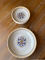 Top view of one large pasta bowl with a colorful central pattern and four smaller matching bowls stacked inside.