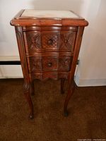 Front view showing two carved drawers, marble top, and cabriole legs.
