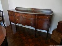 Front view of walnut veneer serpentine-front buffet.