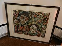 Full view of framed print leaning against wall, showing overall piece and frame