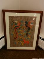 Full view of framed folk art print with birds and deer, showing wood frame and white matting