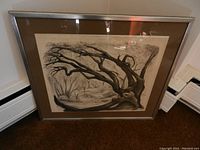 Framed lithograph artwork showing detailed black and white tree branches and a forest scene.