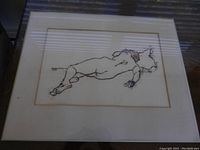 Frontal view of the reclining nude artwork framed in acrylic box frame, showing clear line drawing of nude figure on beige background with reflections on acrylic surface.