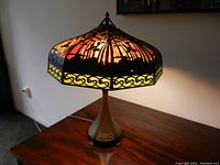 Side view of the lamp lit on a table showing full profile
