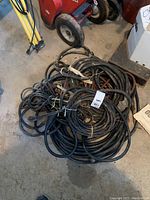 Overhead view of coiled cables and hoses on concrete floor