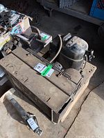 Full compressor unit with attached motor, cylindrical tank, and electrical wiring, dusty and used condition.