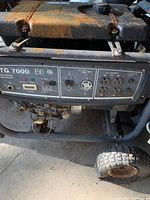 Close-up of the control panel showing various AC and DC outlets, switches, and indicators with rusted fuel tank above