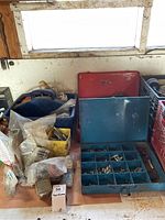 Photo of Bosch drill storage box, bags, and containers filled with hardware such as screws, bolts, and fittings.