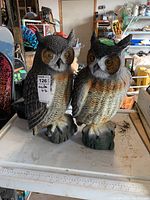 Two Italian resin owl figurines on table with detailed textured feathers and natural colors