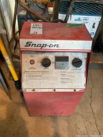 Full front view of red and white Snap-On Super Charger BC5500 welder with controls and labels visible.