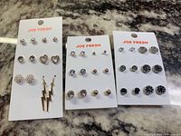 Three cards of Joe Fresh earrings displayed, each card holds 6 pairs in different colors: silver, rose gold, gold.