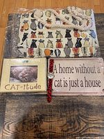 Full lot image showing cat-themed canvas tote bag, metal sign, watch, and picture frame