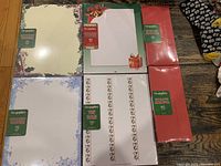 Photo showing all packs of holiday stationery paper, mailing labels, and red envelopes with holiday-themed borders and decorations.