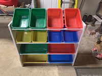 Front view showing white frame with 12 colorful plastic bins: green, red, yellow, and blue in three rows.