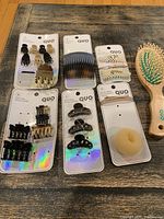 Photo of all Quo hair accessory cards and wooden hairbrush arranged on table