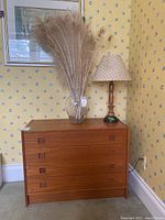Front view of teak veneer dresser with four drawers, rectangular recessed handles, and smooth finish.