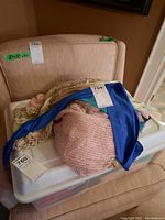 Photo showing three scarves piled: a pink loosely knitted open weave scarf, a vibrant solid blue scarf, and a pink and gold mesh scarf