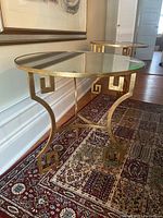 Full view of the circular mirrored top table with brass base showing decorative styling and overall appearance