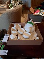 Complete tea set in box arranged with teapot, creamer, sugar bowl, salt and pepper shakers, and cups and saucers.