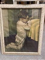Full image of the framed print showing the child praying beside a bed.