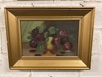Full view of the framed original oil painting showing dark roses in a yellow vase on a table with a green backdrop.