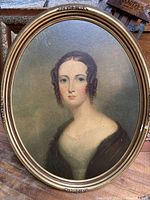 Full view of oval framed portrait showing woman in dark dress