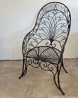 Front-right angle view showing the full chair, the scrollwork in the backrest, and the curled detailing on legs and armrest.