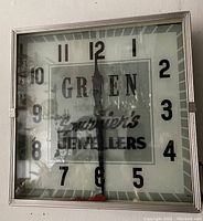 Front view of the vintage square wall clock showing the dial with Gruen and Spurier's Jewellers logo and bold black numbers.