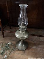 Full view of the vintage oil lamp with base, chimney, and electric cord visible, showing conversion to electric.