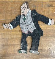 Full view of vintage cartoon butler wooden sign on wood floor, showing overall condition and wear