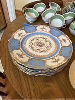 Stack of six Czechoslovak porcelain plates showing blue, white and gold floral patterns.