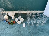 Wide view of all items included in the lot: teapot, creamers, pitchers, glass containers, and sets of glassware