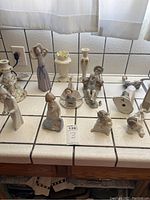 Overview of Lladro figurines and Lenox pieces on tile counter