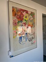 Full view of framed floral wall art showing vibrant flowers in a blue vase and a bowl with fruit, signed Arnold.