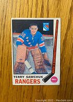 Front of the 1969-70 O-Pee-Chee Terry Sawchuk hockey card showing player in Rangers uniform.