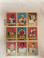 Front side showing images of nine hockey cards from the 1972-73 O-Pee-Chee set featuring players from multiple NHL teams, each with team colors and logos.