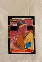 Front of 1987 Leaf Mark McGwire Rookie baseball card showing player image and details.
